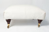 Vintage upholstered ottoman footstool on castors
