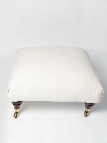 Vintage upholstered ottoman footstool on castors